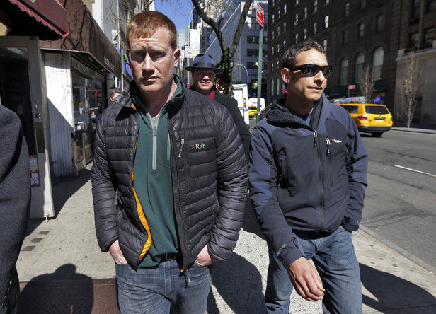 James Brady, left, and Andrew Rossig, right, two parachutists who BASE jumped from One World Trader Center in September 2013, are accompanied by attorney Timothy Parlatore to surrender to police, in New York, Monday, March 24, 2014. (Richard Drew | The Associated Press)